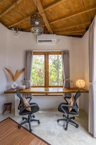 a home office with a desk and two chairs at Villa Capung Padang Padang in Uluwatu