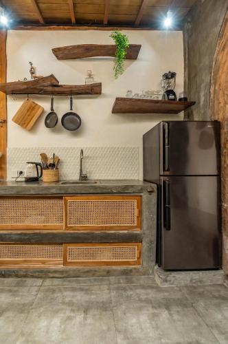 a kitchen with a refrigerator and a sink at Villa Capung Padang Padang in Uluwatu