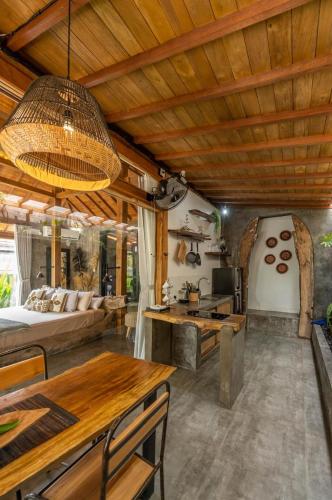 a large living room with a bed and a table at Villa Capung Padang Padang in Uluwatu
