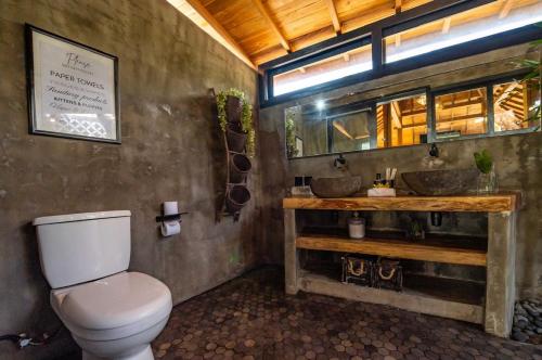 a bathroom with two sinks and a toilet at Villa Capung Padang Padang in Uluwatu