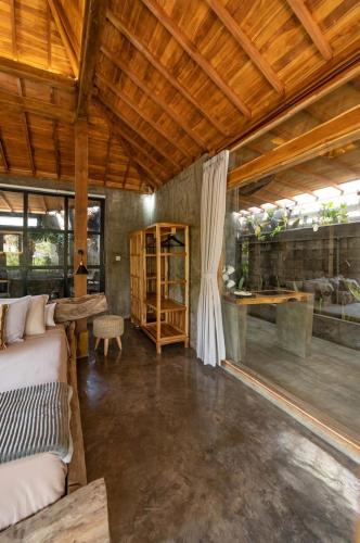 a bedroom with a bed and a wooden ceiling at Villa Capung Padang Padang in Uluwatu