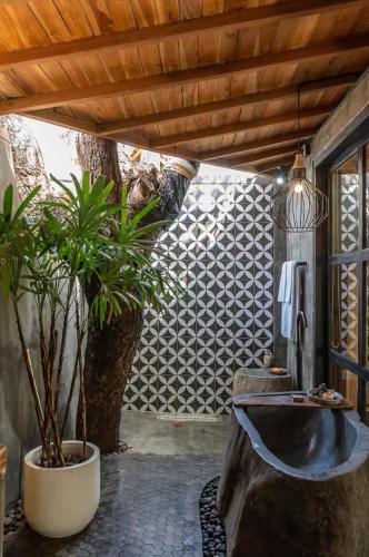 a bathroom with a sink and a potted plant at Villa Capung Padang Padang in Uluwatu