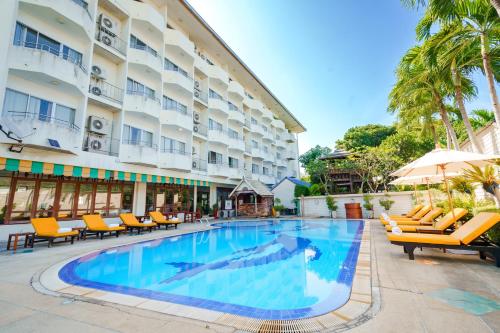 a hotel swimming pool with chairs and a hotel at JP Villa Pattaya in North Pattaya
