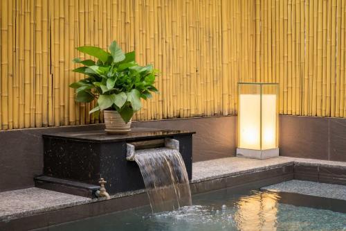 a fountain in front of a building with a plant at Azumaya Kim Mã 3 in Hanoi