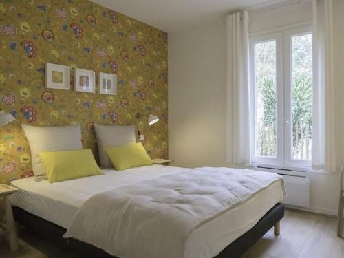 une chambre avec un grand lit avec des oreillers jaunes dans l'établissement Villa Casa Anna au Moulleau PYLA SUR MER, à Arcachon