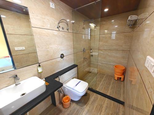 a bathroom with a toilet and a sink and a shower at Opulence Inn - 500 Meters From Railway Station in Udaipur