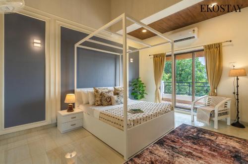 a bedroom with a canopy bed and a balcony at EKOSTAY - Amanta Hills 7BHK in Karjat