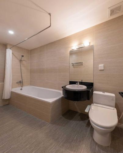 a bathroom with a tub and a toilet and a sink at Azumaya Kim Mã 3 in Hanoi
