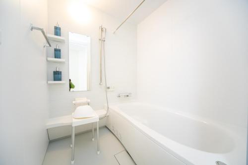 a white bathroom with a white tub and a white chair at Miraie Awaji Kuruma95 in Awaji