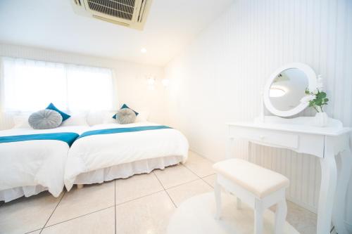 a white bedroom with a white bed and a mirror at Miraie Awaji Kuruma95 in Awaji