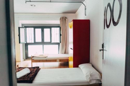 a small room with two beds and a window at Black Swan Hostel in Barcelona