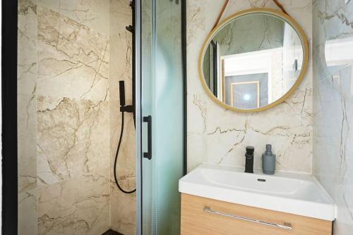 une salle de bain avec un lavabo et un miroir dans l'établissement Appartement Suite 12 aux Portes de Paris, à Aubervilliers