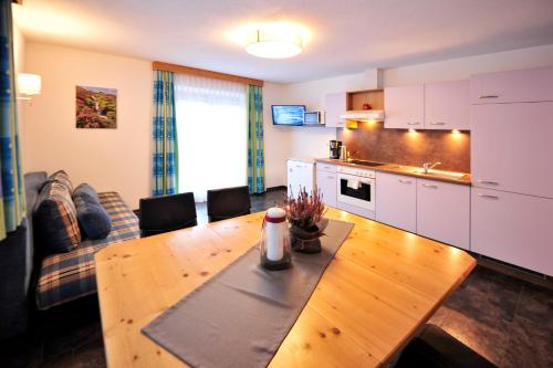 a kitchen and a living room with a wooden table at Bäckerei Schranz in Sankt Leonhard im Pitztal