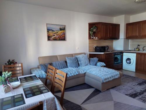 a living room with a couch and a kitchen at Bansko Pirin Golf & Country Club Blue Mountains View in Razlog