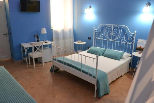 um quarto azul com uma cama e uma mesa em B&B O Casteddu em Monforte San Giorgio