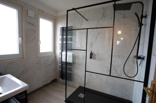 une salle de bain avec une douche avec une porte vitrée dans l'établissement Villa Evasion, à Louviers