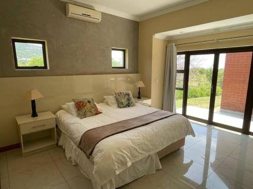 a bedroom with a large bed and a window at Euphoria Golf Estate House 196 Rooibok in Naboomspruit
