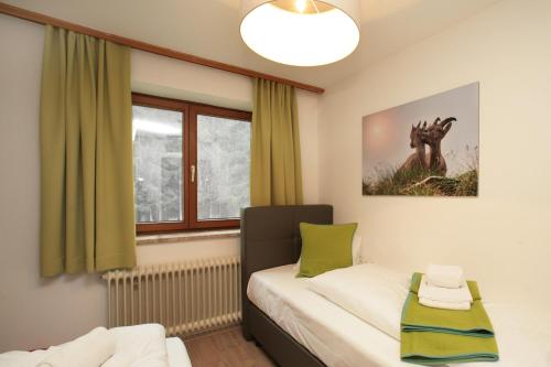 a small bedroom with a bed and a window at Premium Chalet Andrea in Leogang