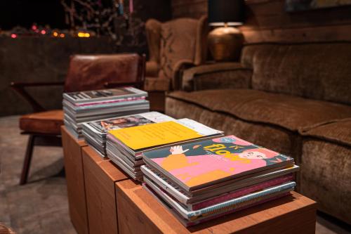 a pile of books on a table in a living room at Boutique Aparthotel Chalets Coburg in Schladming
