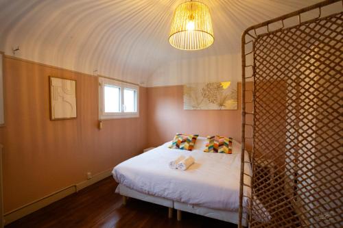 une chambre avec un lit avec un couvre-lit blanc dans l'établissement Villa Evasion, à Louviers