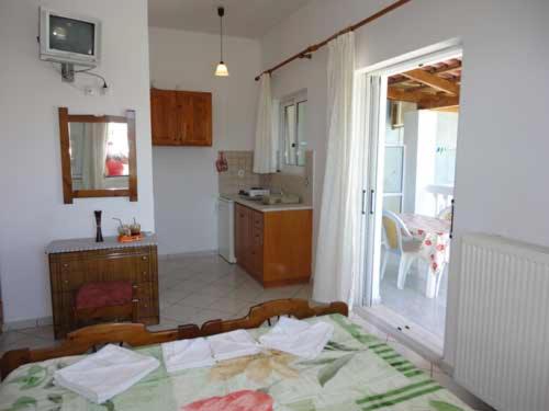 a room with a kitchen and a bed in a room at Lazanis Studios Apartments in Laganas