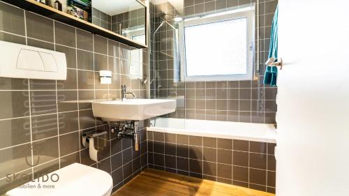 une salle de bain avec un lavabo et des toilettes et une fenêtre dans l'établissement Haus Luchre Zermatt Wohnung mit Matterhornblick, à Zermatt