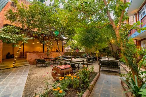 a restaurant with tables and chairs under a tree at Kwabahal Boutique Hostel in Kathmandu