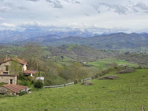a view of a valley with mountains and a fence at Vivienda Vacacional La Macona in Infiesto