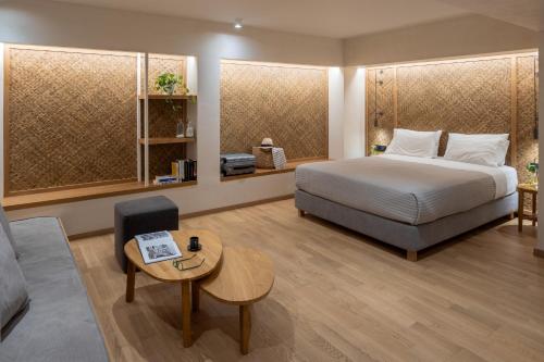 a bedroom with a bed and a table and a couch at Atrium Hotel in Agia Paraskevi