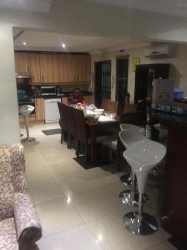 a kitchen and living room with a table and chairs at The Raps Guesthouse in Meadowlands
