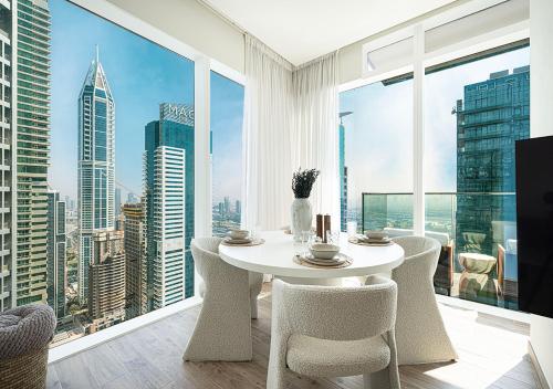 a white table and chairs in a room with a large window at Jumeirah Living Marina Gate - Golf & Skyline Views with Pool & Gym in Dubai