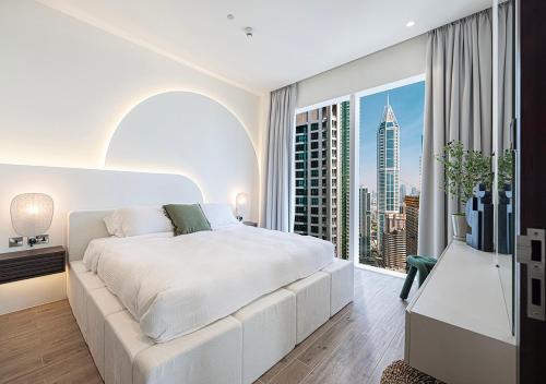 a bedroom with a large white bed and a large window at Jumeirah Living Marina Gate - Golf & Skyline Views with Pool & Gym in Dubai