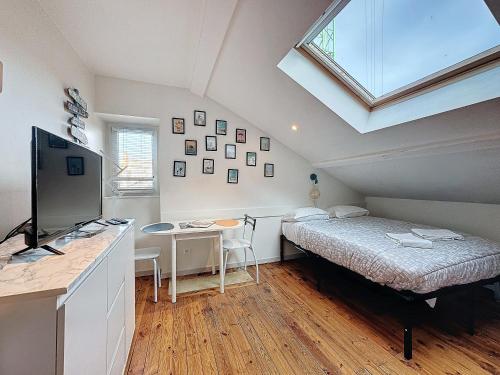 une chambre avec un lit et un bureau avec une télévision dans l'établissement Studio Avenue de la République - A, à Clermont-Ferrand