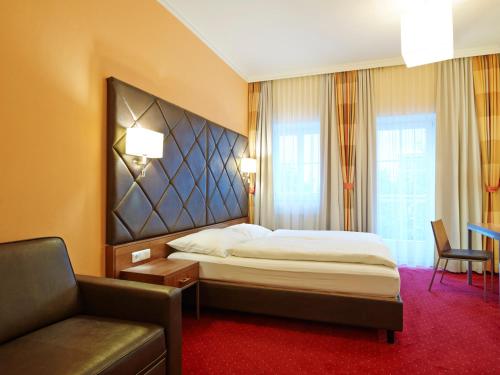a hotel room with a bed and a couch at Villa Ceconi by Das Grüne Hotel zur Post - 100% BIO in Salzburg