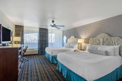 a hotel room with two beds and a flat screen tv at La Posada Lodge & Casitas, an Ascend Collection Hotel in Tucson