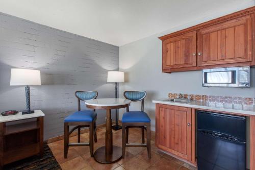 a kitchen with a small table and two stools at La Posada Lodge & Casitas, an Ascend Collection Hotel in Tucson