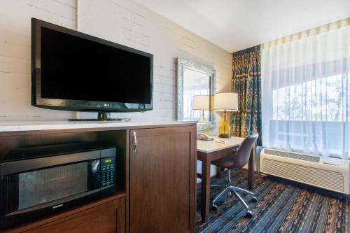 a hotel room with a desk and a tv and a computer at La Posada Lodge & Casitas, an Ascend Collection Hotel in Tucson