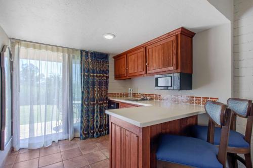 a kitchen with wooden cabinets and a large window at La Posada Lodge & Casitas, an Ascend Collection Hotel in Tucson