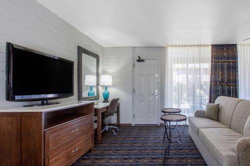 a living room with a flat screen tv and a couch at La Posada Lodge & Casitas, an Ascend Collection Hotel in Tucson