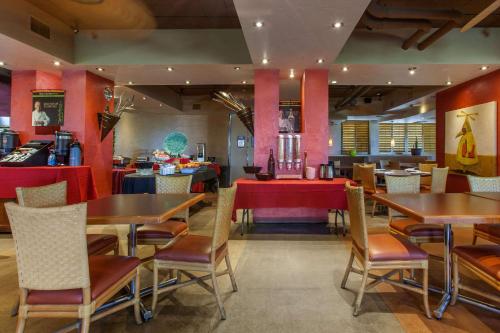 a dining room with tables and chairs in a restaurant at La Posada Lodge & Casitas, an Ascend Collection Hotel in Tucson
