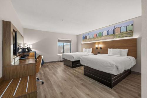 a hotel room with two beds and a television at Clarion Pointe Lakeland I-4 in Lakeland