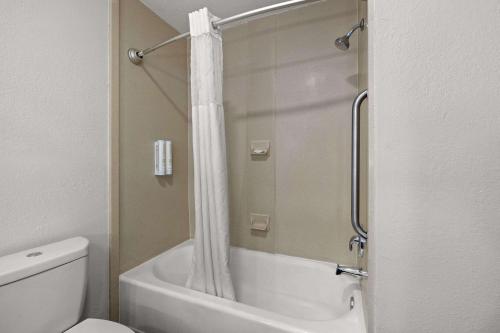 a bathroom with a tub and a shower with a toilet at Clarion Pointe Lakeland I-4 in Lakeland