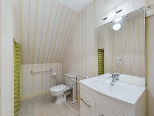 une salle de bain avec un lavabo blanc et des toilettes dans l'établissement -HANSEL- Belle Chaumiere a Kerascoet, à Névez