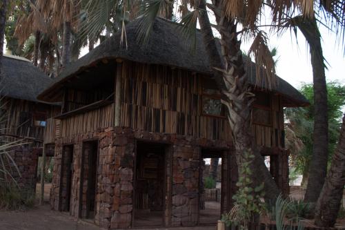 an old building with a tree in front of it at Epupa Falls Lodge in Epupa