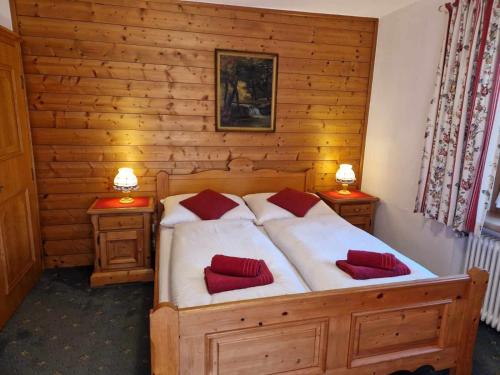a bedroom with a bed with red pillows on it at Pension Alpenrose in Kitzbühel