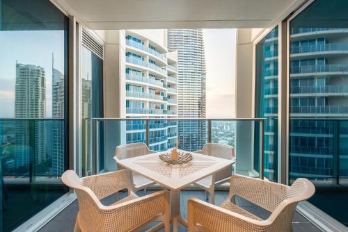 a balcony with a table and chairs and views of the city at Hilton Surfers Paradise Luxury Suite - 2Bedroom, Free Car Park in Gold Coast