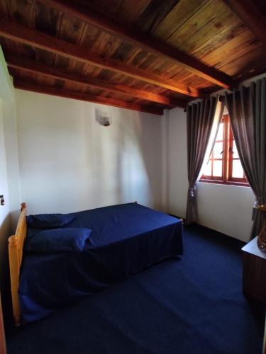 a bedroom with a blue bed and a window at The Mount Lodge in Nuwara Eliya