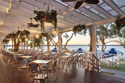 a row of tables and chairs on a deck at The Beachcomber Hotel & Resort, an Ascend Collection Resort in Toukley