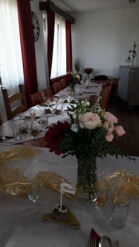 a long table with a vase of flowers on it at wellness Chata u Pinkasů in Písečná
