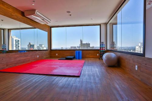 a large room with a red rug and large windows at Radisson RED Campinas in Campinas